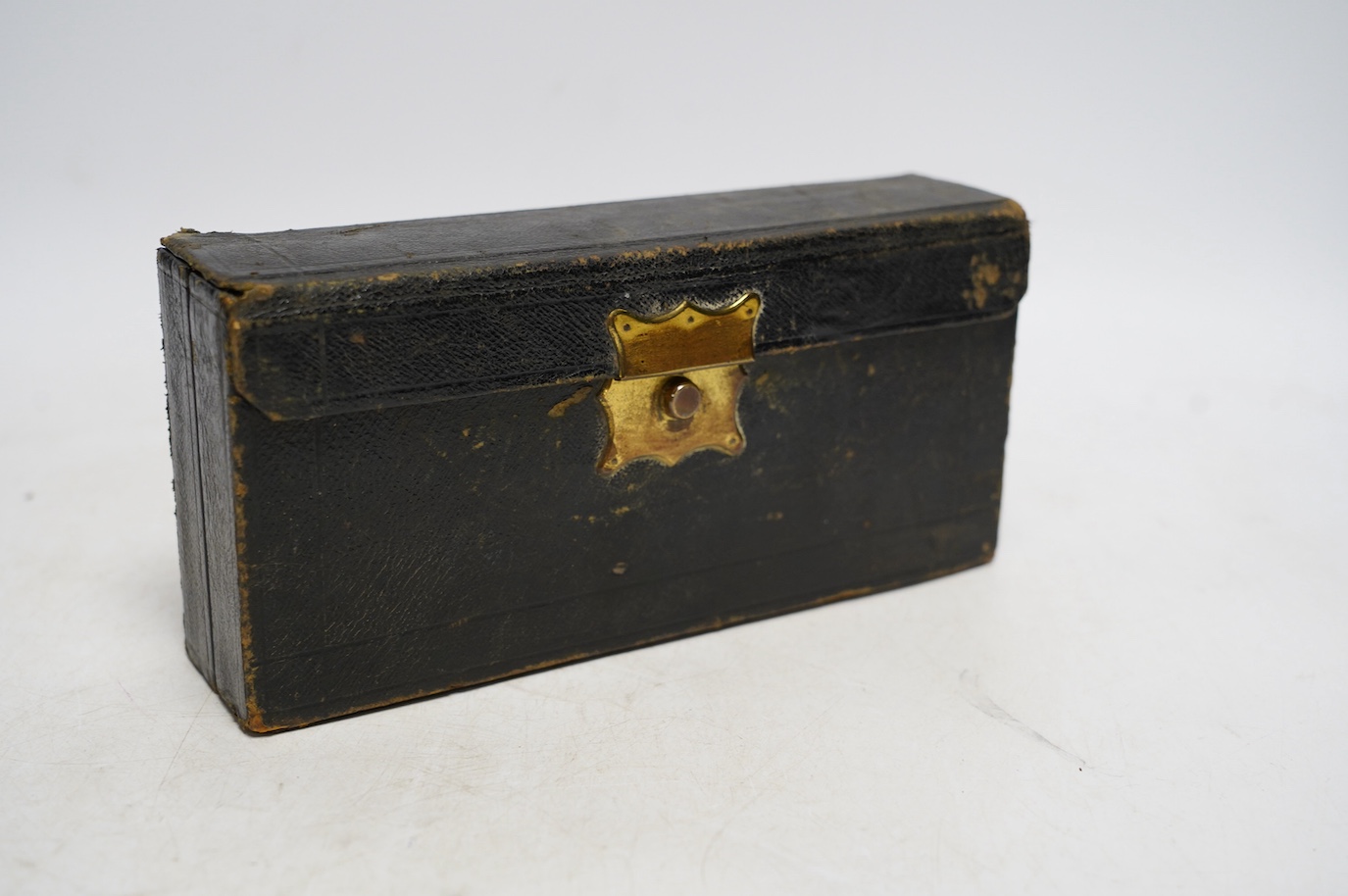 A late 19th century leather cased perfume or apothecary set by Lynch & Co., containing seventeen miniature bottles with old labels, (seven bottles missing), 20.5cm x 10cm x 4.5cm. Condition - fair